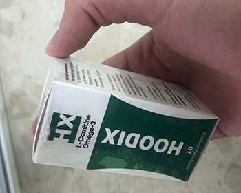 Упаковка hoodix для похудения в руках у мужчины
