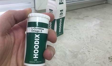 Банка таблеток hoodix для похудения в руках
