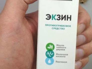 Коробка препарата Экзин против грибка в руке мужчины.